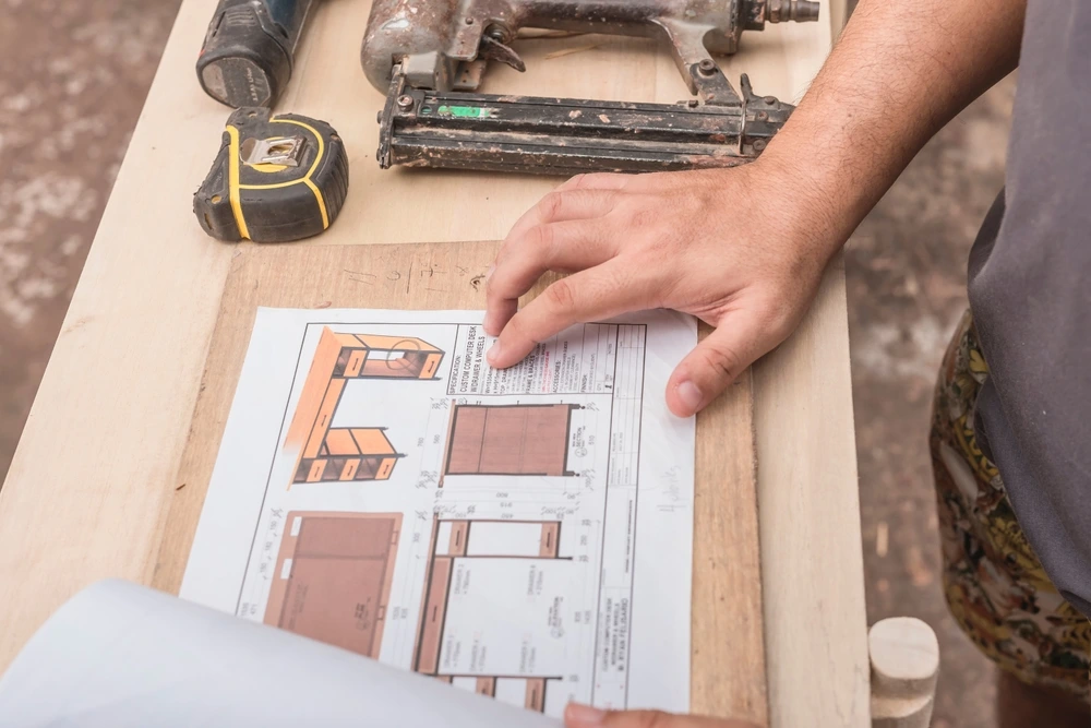 Woodwork planning carpenter studying cabnet blueprint 