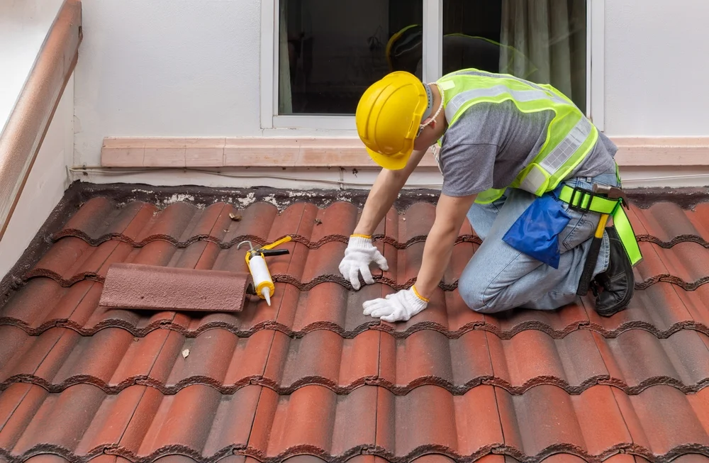 handyman repairing roof tiles